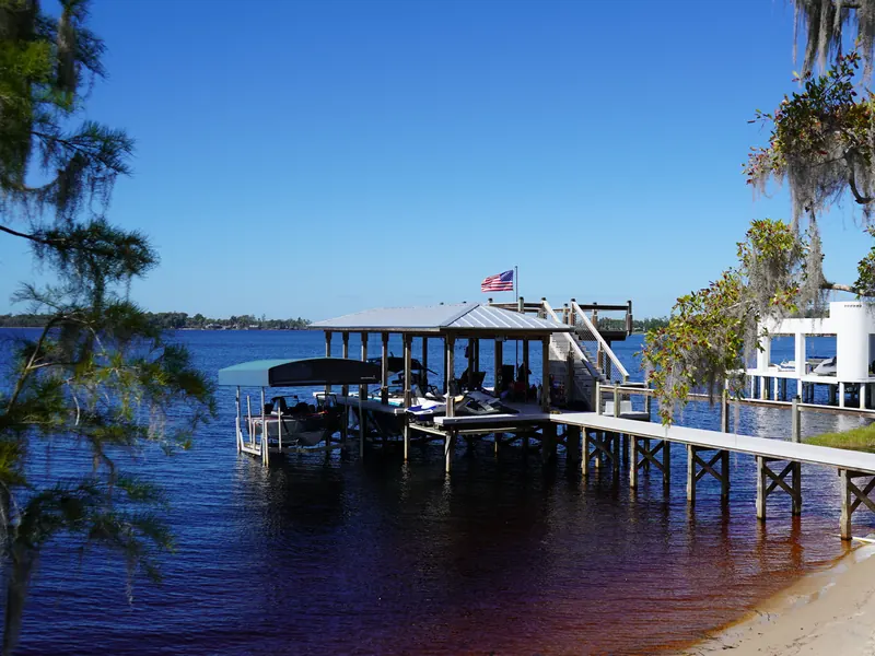 Clean wooden dock and two-story boathouse stretching out over a Central Florida lake